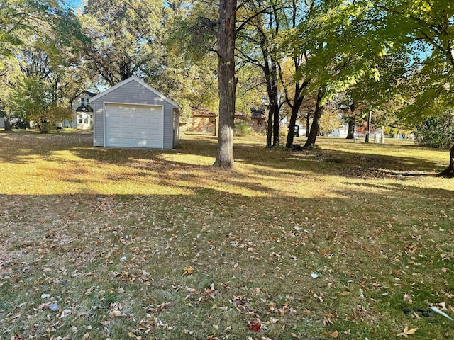 view of yard featuring a garage and an outbuilding