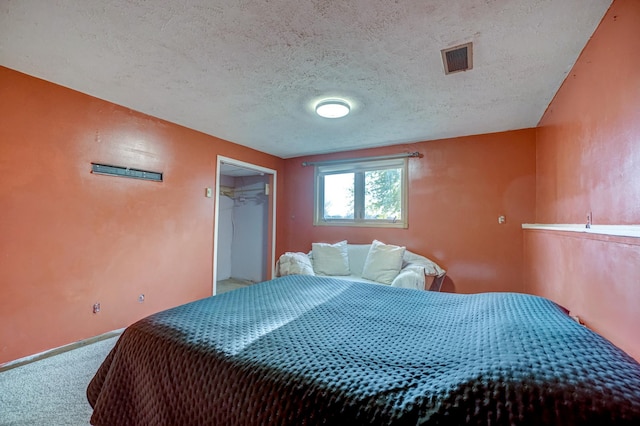 bedroom with visible vents, carpet floors, a textured ceiling, and baseboards