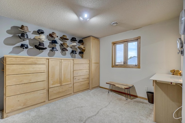 interior space featuring a textured ceiling and baseboards