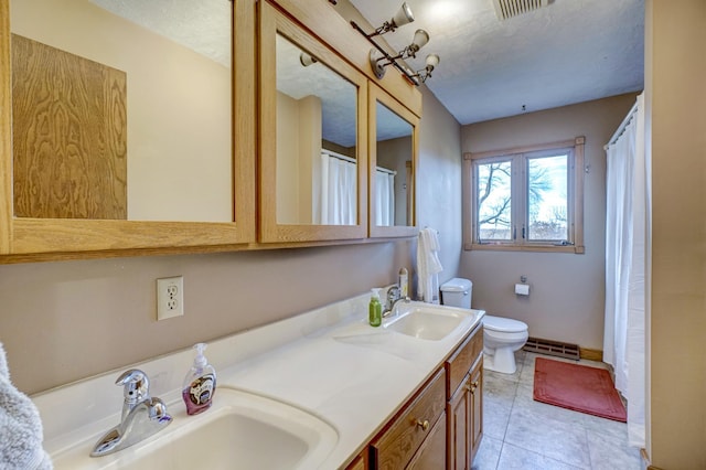 full bath with a sink, visible vents, toilet, and tile patterned flooring