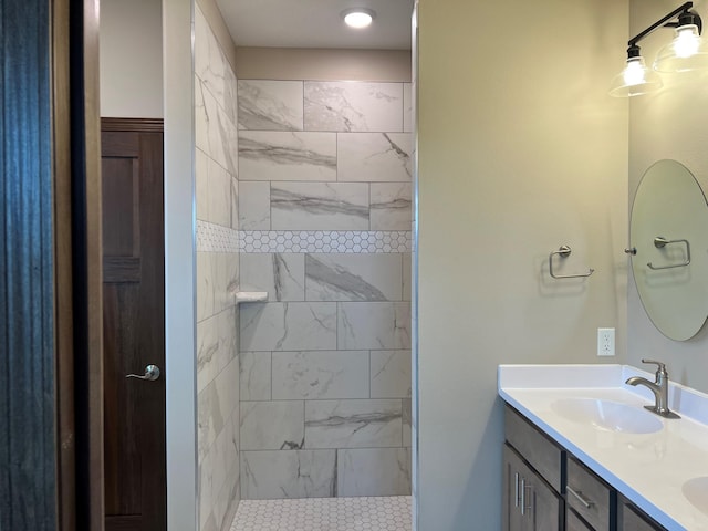 bathroom with vanity and a tile shower