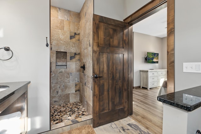 bathroom featuring vanity, hardwood / wood-style flooring, and tiled shower