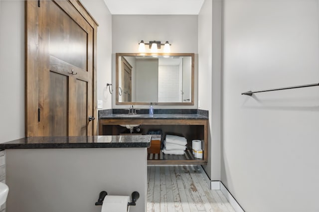 bathroom featuring toilet, sink, and hardwood / wood-style floors