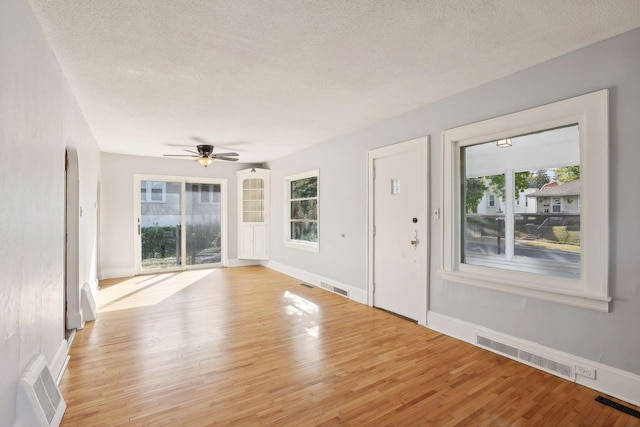 entryway featuring ceiling fan, light hardwood / wood-style floors, and a textured ceiling