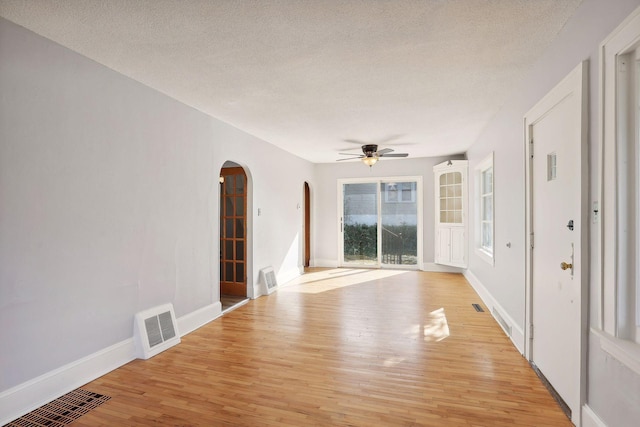 unfurnished room featuring ceiling fan, light hardwood / wood-style flooring, and a textured ceiling