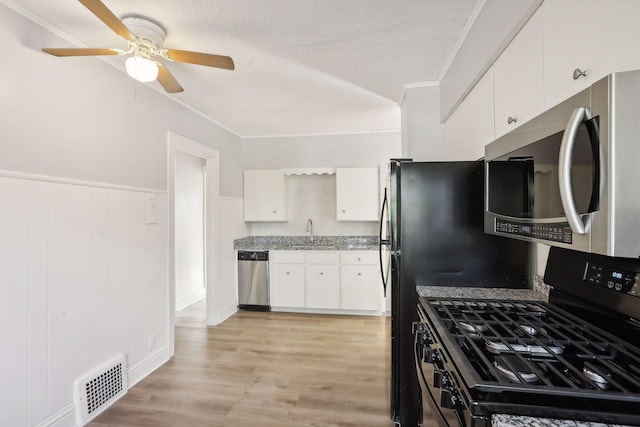 kitchen featuring sink, white cabinets, stainless steel appliances, and light hardwood / wood-style floors