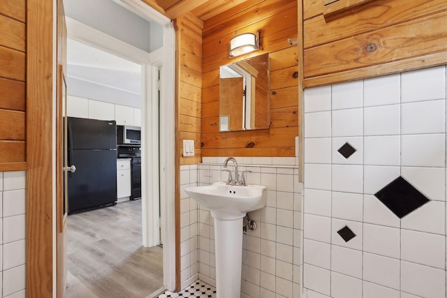 bathroom featuring hardwood / wood-style flooring, sink, and tile walls