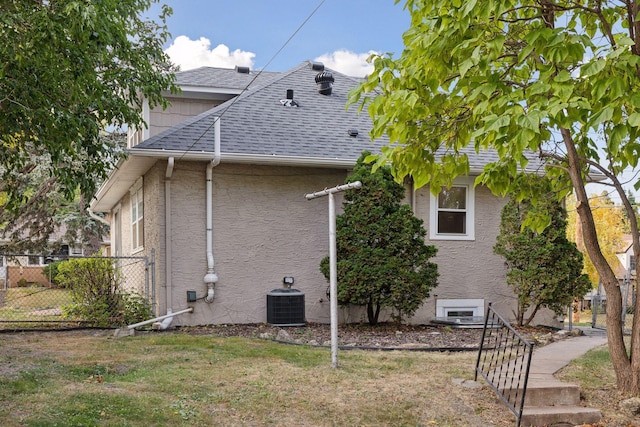 view of side of home with a lawn and central AC unit