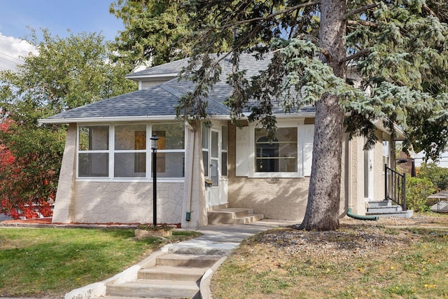 view of front of home featuring a sunroom and a front lawn