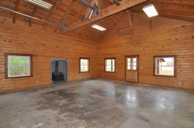 31071 State 34, Akeley Twp, MN 56433 - unfurnished living room with wooden walls, high vaulted ceiling, concrete floors, and a wood stove