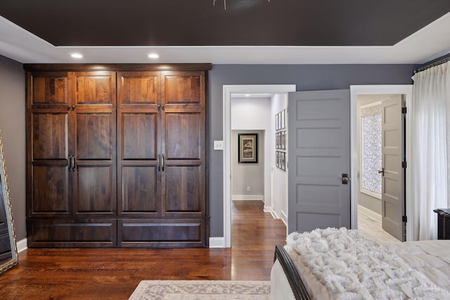 bedroom with dark hardwood / wood-style flooring