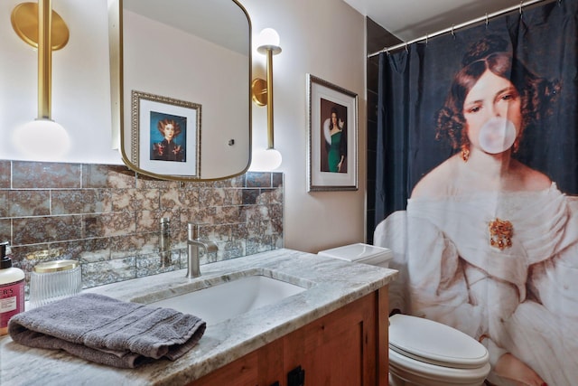 bathroom featuring vanity, tasteful backsplash, and toilet