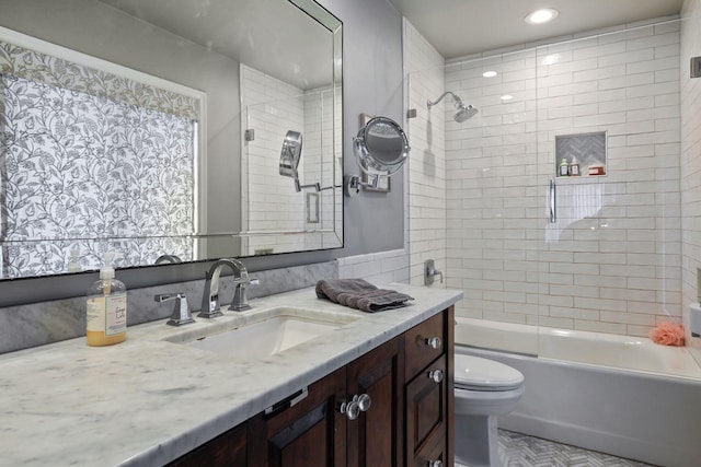 full bathroom with vanity, tiled shower / bath, and toilet