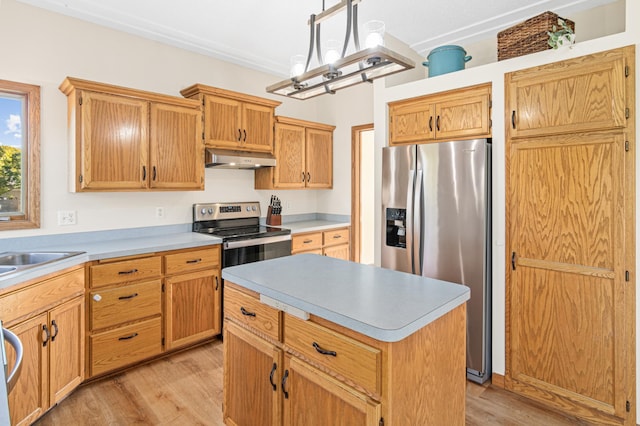 kitchen featuring a kitchen island, light hardwood / wood-style flooring, hanging light fixtures, a notable chandelier, and appliances with stainless steel finishes