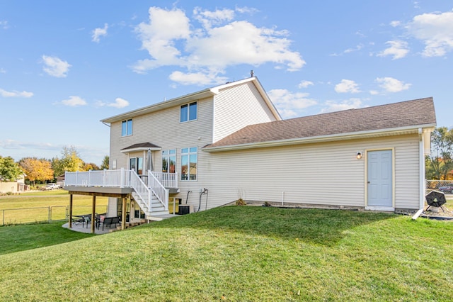 rear view of house with a yard, a deck, and central air condition unit