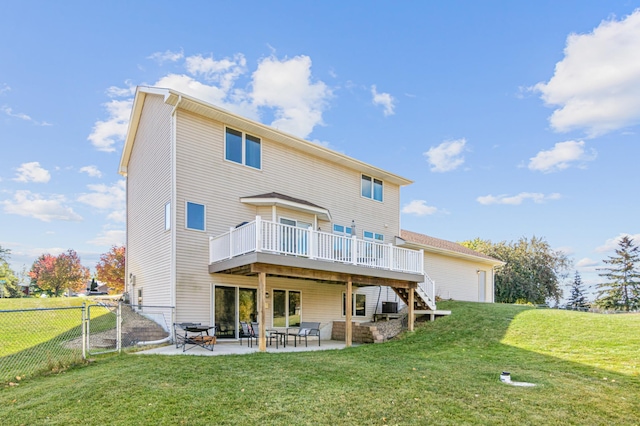 rear view of property featuring a patio, a wooden deck, and a yard