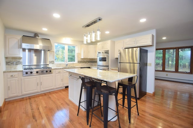 kitchen featuring light wood-type flooring, decorative backsplash, stainless steel appliances, and white cabinets