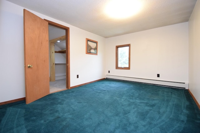 unfurnished room with a baseboard heating unit, baseboards, and carpet floors