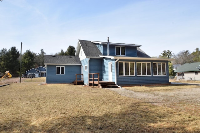 rear view of property with a yard, a deck, and a shingled roof