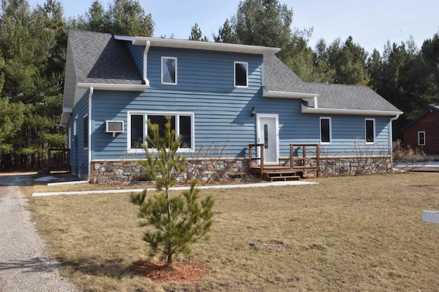 view of front of home with an AC wall unit, a front yard, and roof with shingles