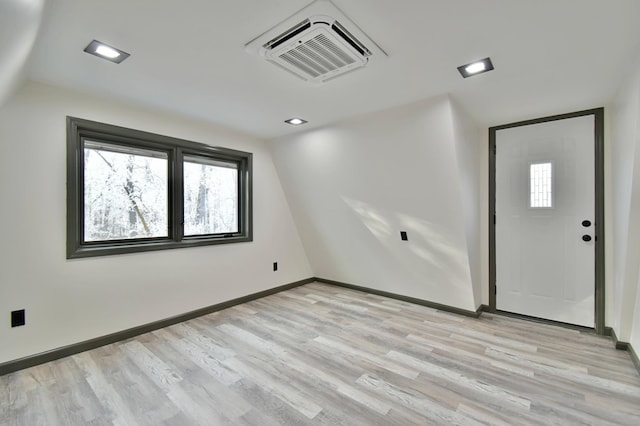 interior space with vaulted ceiling and light hardwood / wood-style flooring