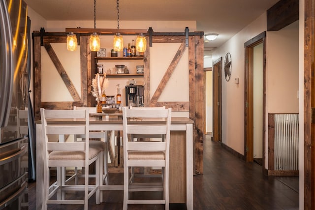 bar with stainless steel fridge, a barn door, dark wood-type flooring, and pendant lighting