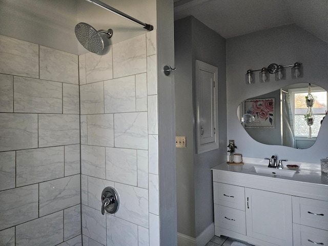 bathroom featuring vanity, lofted ceiling, and tiled shower