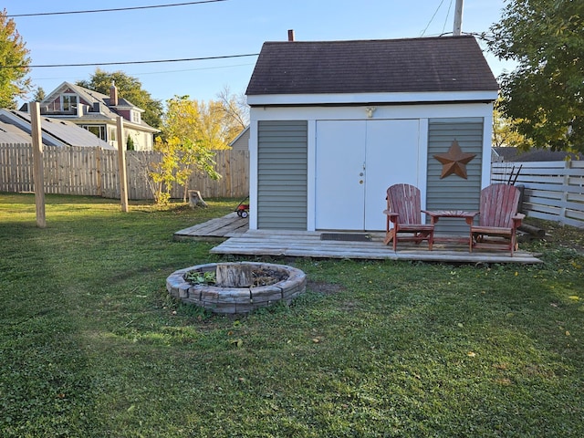 view of outdoor structure featuring a yard and an outdoor fire pit