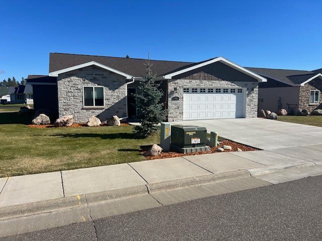 ranch-style home with a garage and a front lawn