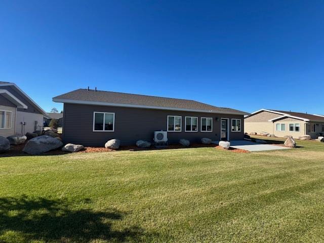 back of house with ac unit and a yard