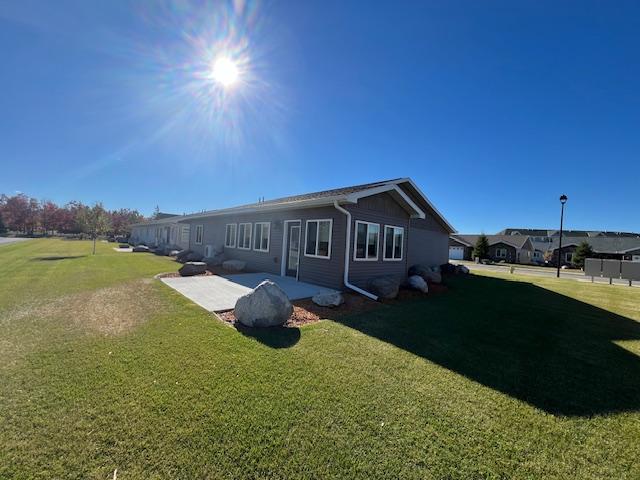 back of house with a patio and a yard