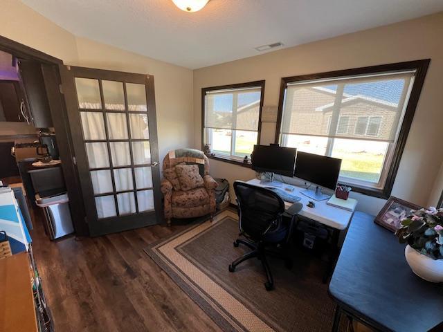 home office featuring dark hardwood / wood-style flooring and a healthy amount of sunlight