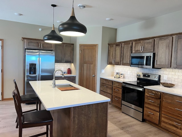 3106 Bassett Dr, Mankato, MN 56001 - kitchen featuring light wood-style flooring, a sink, backsplash, light countertops, and appliances with stainless steel finishes