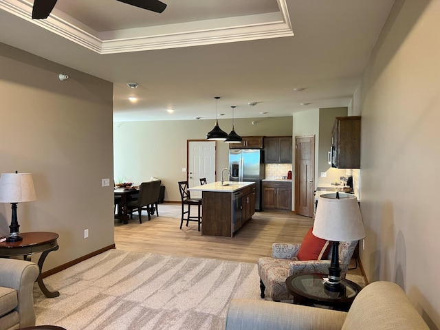 3106 Bassett Dr, Mankato, MN 56001 - living room featuring light wood-style flooring, a tray ceiling, crown molding, baseboards, and light colored carpet