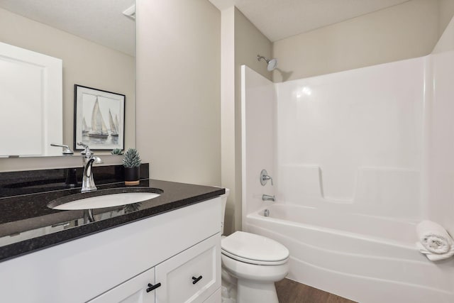 full bathroom with bathing tub / shower combination, hardwood / wood-style floors, vanity, and toilet