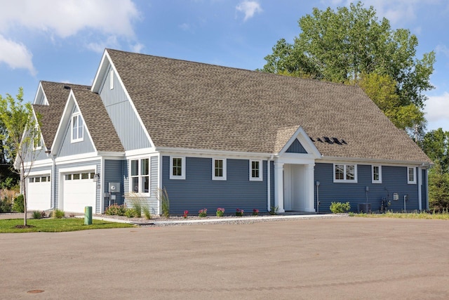 view of front of house with board and batten siding, roof with shingles, and an attached garage