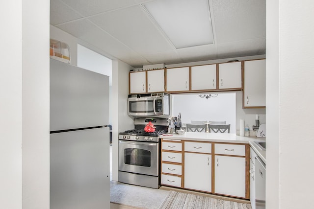 kitchen featuring appliances with stainless steel finishes, a paneled ceiling, and white cabinetry