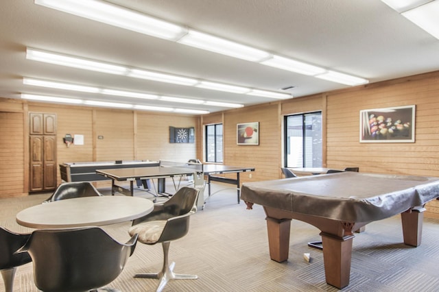 playroom featuring light carpet, wood walls, and pool table