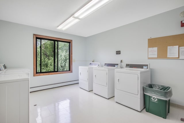 laundry area with baseboard heating and washer and clothes dryer