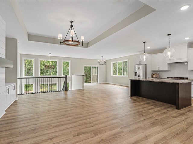 kitchen with white cabinetry, stainless steel refrigerator with ice dispenser, light wood-type flooring, and a wealth of natural light