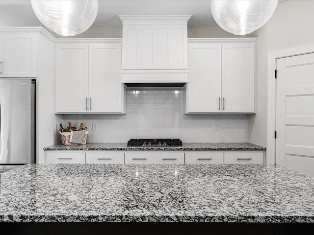 kitchen featuring gas stovetop, white cabinetry, and stainless steel refrigerator