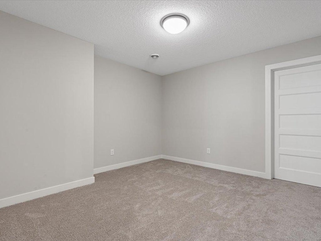 carpeted spare room with a textured ceiling