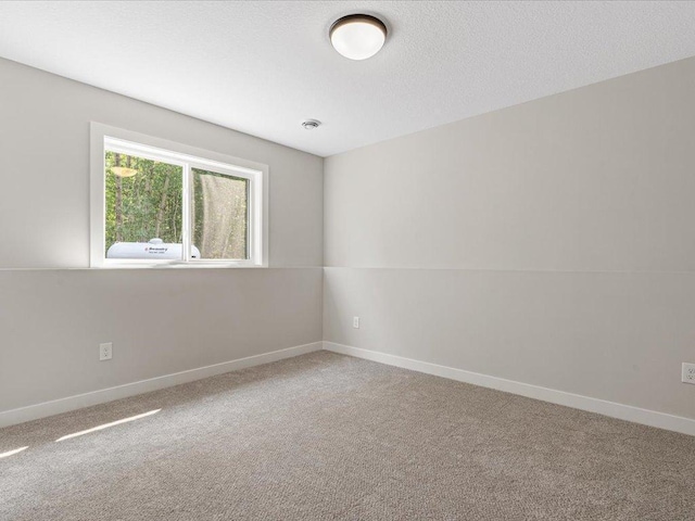 carpeted empty room featuring a textured ceiling