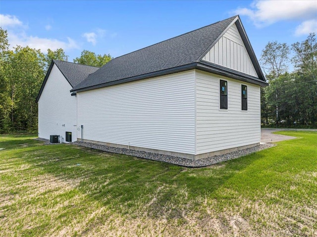 view of side of property with central AC and a yard