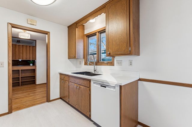 kitchen with sink, dishwasher, and light wood-type flooring