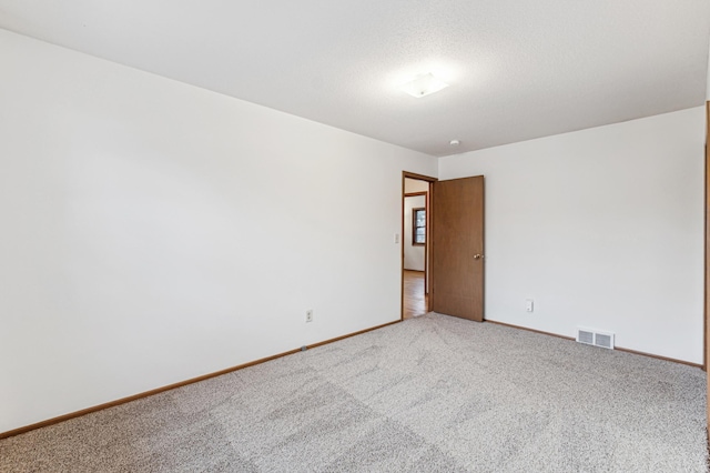 empty room featuring a textured ceiling and carpet flooring