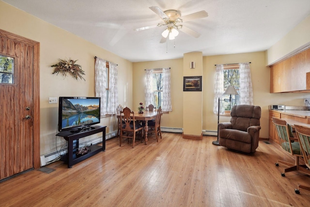 sitting room featuring baseboard heating, light hardwood / wood-style floors, and ceiling fan