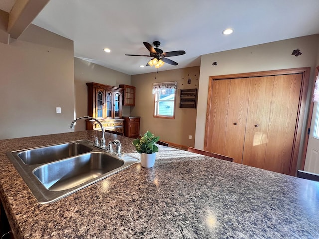 kitchen featuring beamed ceiling, ceiling fan, and sink