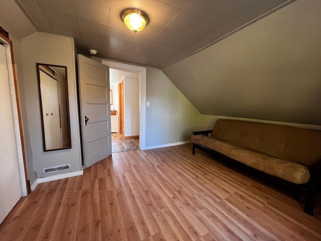 bonus room with vaulted ceiling and light hardwood / wood-style flooring