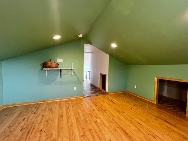 bonus room with wood-type flooring and vaulted ceiling